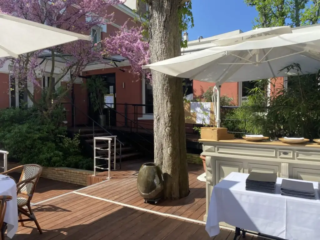 Tree-lined terrace at Villa9Trois restaurant in Montreuil
