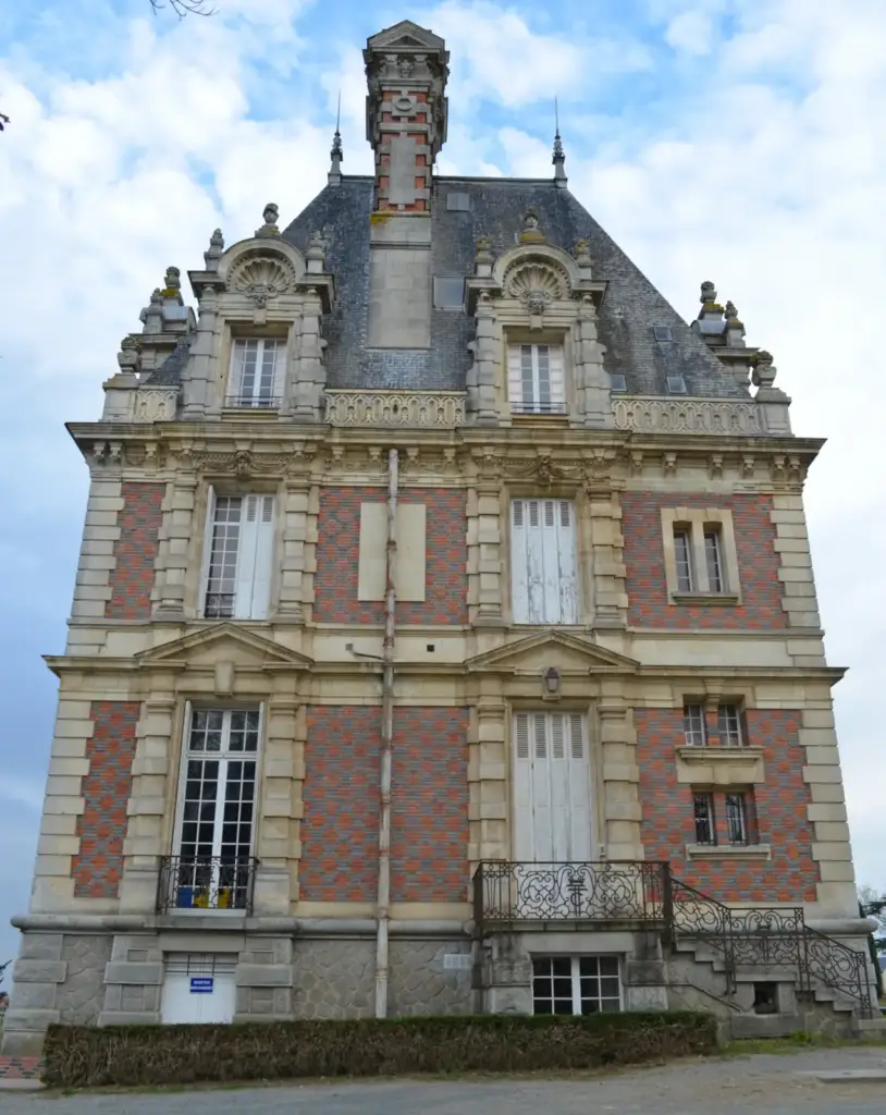 Façade latérale du château de la Turmelière avec haute cheminée, lucarnes et escalier extérieur
