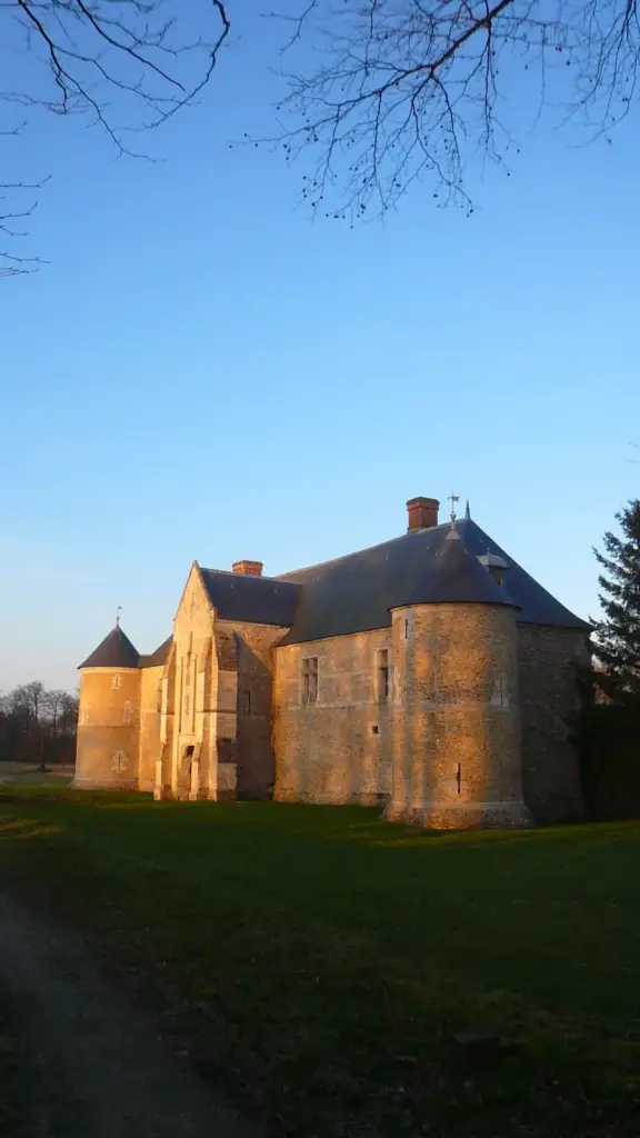 Façade en pierre et tours du Manoir du Catel à la lumière du soir