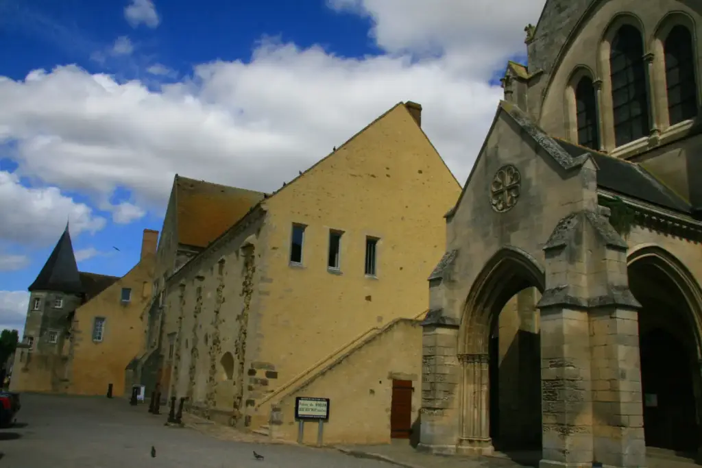 Bâtiment du prieuré de Vivoin avec l’église voisine au premier plan, vue de 2009