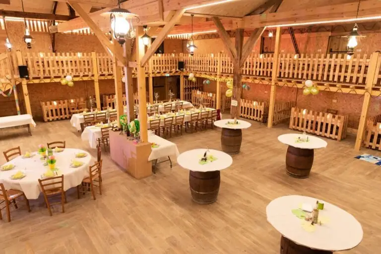 Inside the Saloon at Western City, with a timber gallery, laid tables and barrel-based cocktail tables.