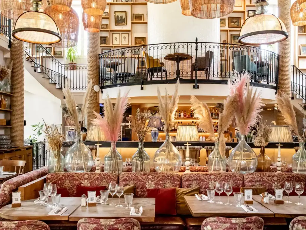 Salle du restaurant L’Île à Issy-les-Moulineaux avec tables dressées et mezzanine