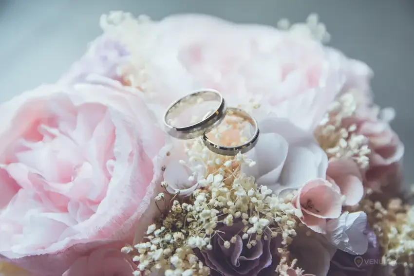 Bague de mariage dorée déposée sur un bouquet de fleurs
