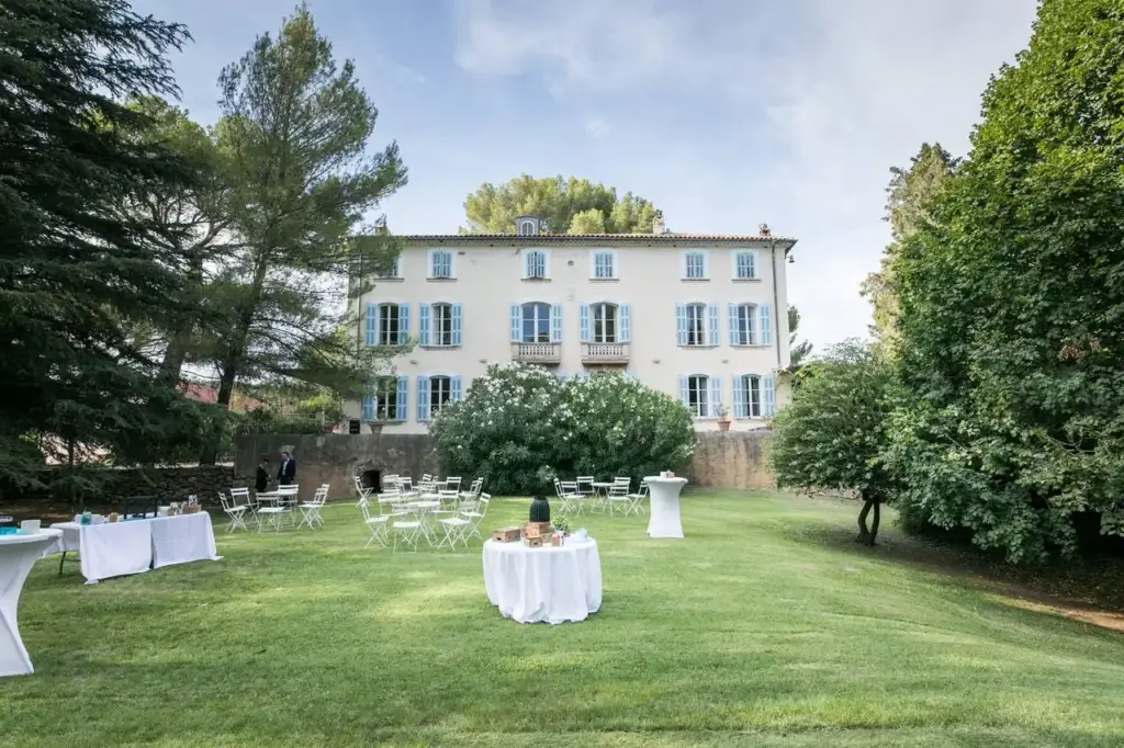 Façade aux volets bleus du Domaine de Sigalous à La Crau, devant le parc aménagé pour une réception