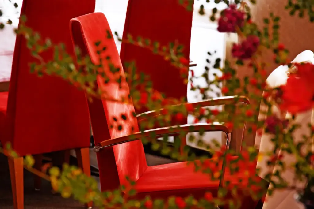 Fauteuils rouges et décoration végétale dans le salon du Moulin de La Wantzenau