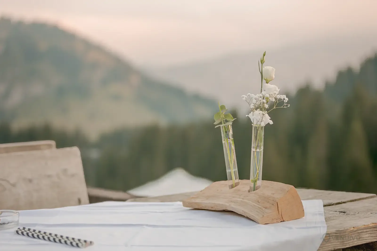 Table de mariage champêtre avec fleurs et paysage naturel