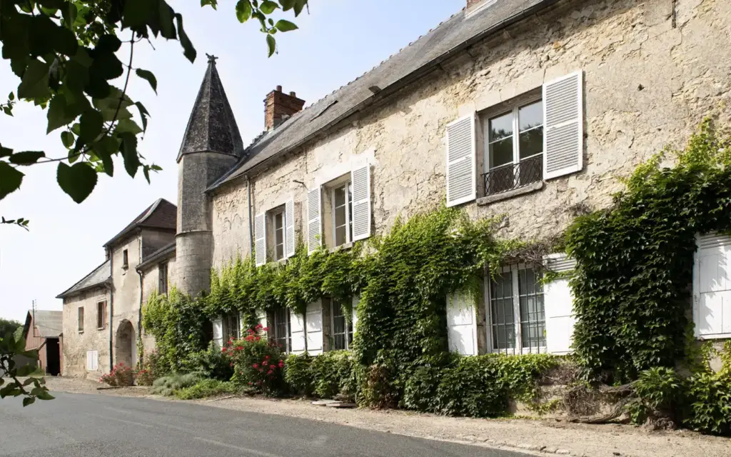 Façade en pierre et tourelles de La Ferme des Tournelles à Duvy