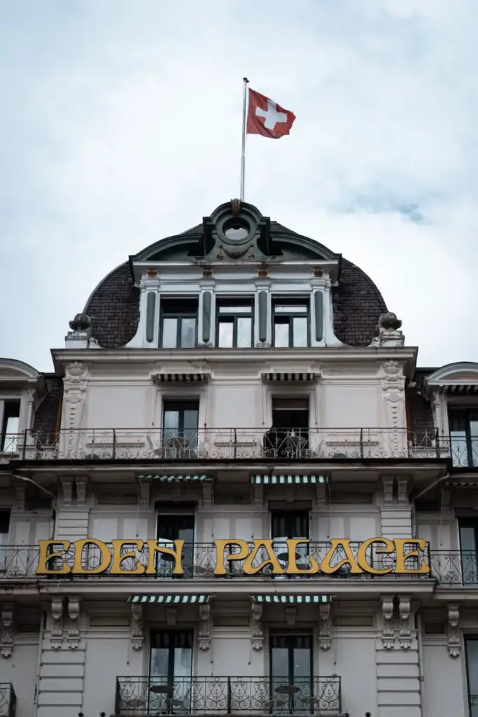 Façade of Eden Palace au Lac in Montreux with its sign and the Swiss flag