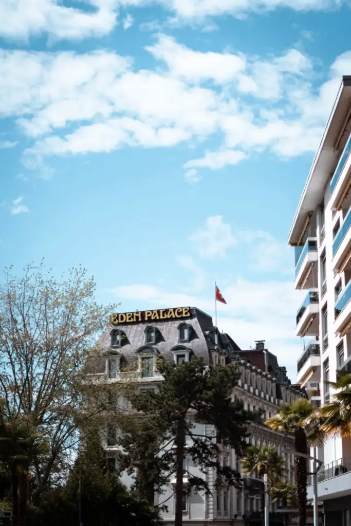 Exterior view of Eden Palace au Lac with its sign and trees in Montreux