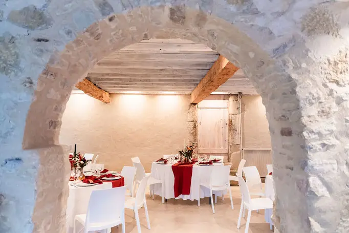 Salle de réception du Domaine En Galinier avec voûte en pierre et tables dressées