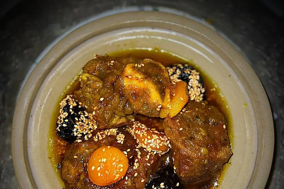 Tajine de viande aux pruneaux et fruits secs parsemé de graines de sésame, présenté par HBK Traiteur