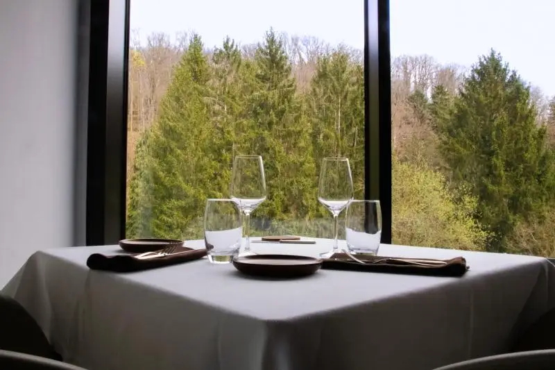 Table dressée au restaurant du 6717 avec vue sur la forêt