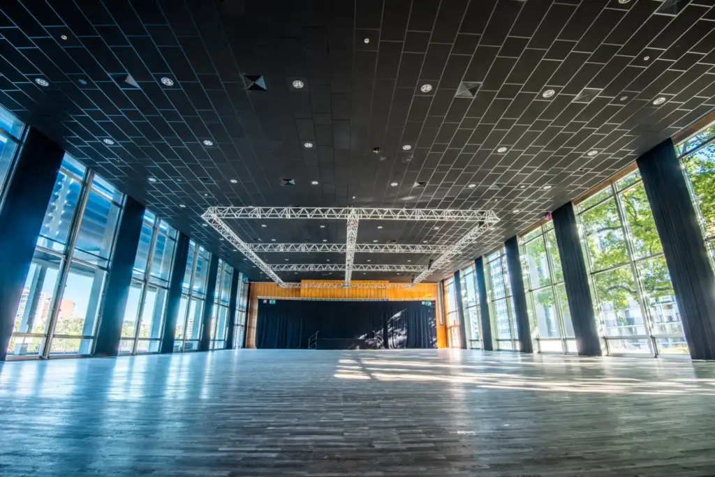 Vue d’ensemble de la Salle des Fêtes du Palais des Congrès de Liège, avec parquet, baies vitrées et scène