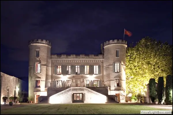 Façade illuminée et deux tours du Château de Pouget