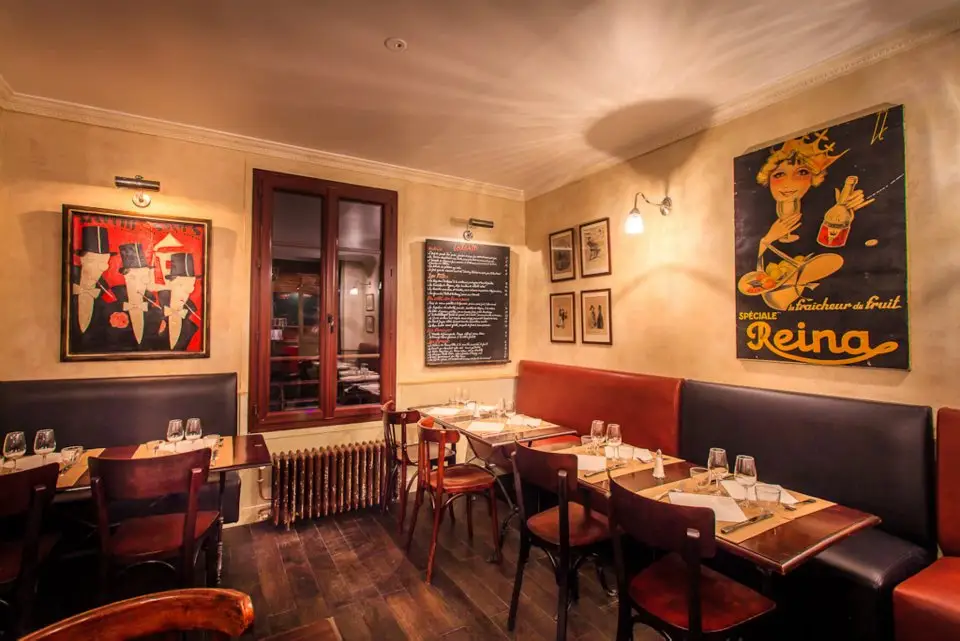 Salle du restaurant Le Père Louis à Neuilly-Plaisance avec banquettes et affiches anciennes