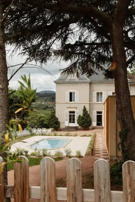 Vue de la maison de maître et de la piscine du Château des Vierres depuis le jardin