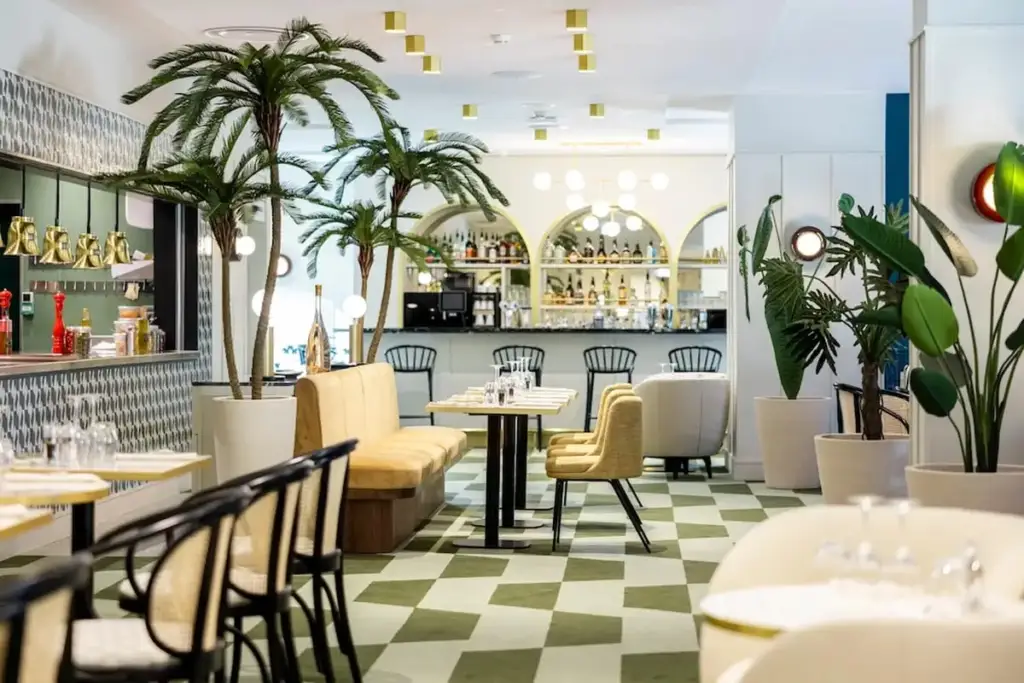 Salle du restaurant du Pasino de Hyères avec tables dressées, banquettes et bar
